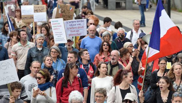 Los manifestantes sostienen pancartas y corean consignas mientras marchan durante una manifestación en Nantes, en el oeste de Francia para protestar contra el pase de salud obligatorio Covid-19 para acceder a la mayor parte del espacio público. (Foto: Sebastien SALOM-GOMIS / AFP)