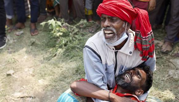 Dos familiares lloran mientras los rescatistas recuperan cuerpos tras el naufragio de un transbordador que chocó el domingo por la noche con un carguero en el Río Shitalakkhya, en el distrito de Narayanganj, a las afueras de la capital de Bangladesh, el lunes 5 de abril de 2021. (Foto: AP/Mushfiqul Alam)