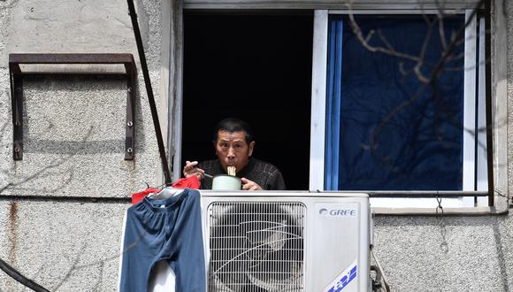Un habitante de Wuhan que está en cuarentena por el coronavirus mira desde la ventana de su vivienda. (Reuters).