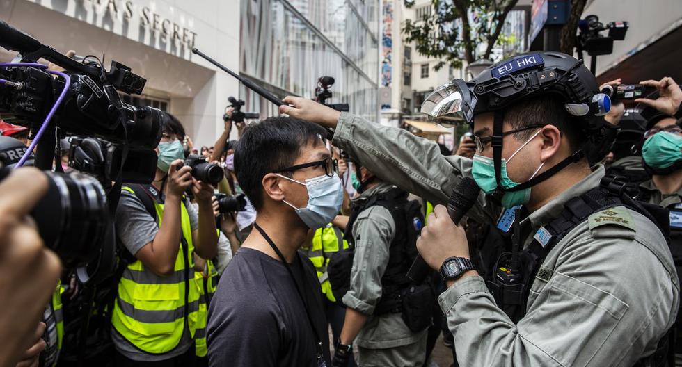 La policía vigila la salida de una estación del metro, cerca del Consejo Legislativo, en Hong Kong, antes de un debate sobre una ley que prohíbe insultar el himno nacional de China. (ISAAC LAWRENCE / AFP)