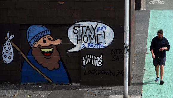 En Escocia, un hombre camina cerca de un graffiti con la frase "quedarse en casa es brutal". En dicho lugar la cuarentena por el Covid-19 ha empezado a ser menos estricta. Foto: AFP.