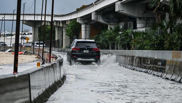 Un automóvil circula por la calle inundada durante las fuertes lluvias en Miami, Florida, el 12 de abril de 2023 (Foto: CHANDAN KHANNA / AFP)