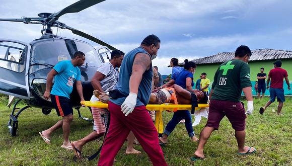 Trabajadores de la salud e indígenas cargando a un indígena yanomami herido en el aeródromo de Surucucu, municipio de Alto Alegre, estado de Roraima, Brasil, el 29 de abril. , 2023. (Foto referencial de Antonio ALVARADO / Urihi Yanomami Association / AFP)