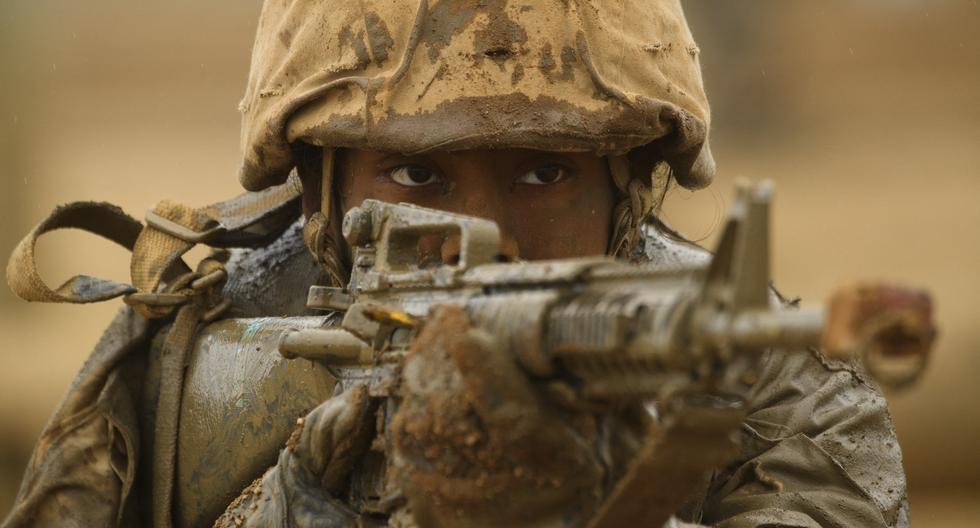 Una recluta del Cuerpo de Marines de Estados Unidos (USMC) de Lima Company apunta su rifle mientras está cubierta de barro durante un entrenamiento el 21 de abril de 2021 en Camp Pendleton, San Diego, California. (Foto de Patrick T. FALLON / AFP).