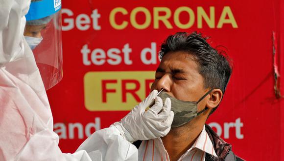 Un trabajador de la salud que usa equipo de protección personal (EPP) recolecta una muestra de hisopo de un hombre durante una campaña de prueba rápida de antígenos para la enfermedad del coronavirus en un quiosco en Ahmedabad, India. (REUTERS / Amit Dave).