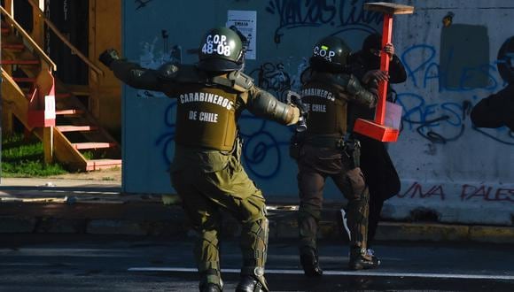 Manifestantes chocan con la policía antidisturbios durante una protesta para conmemorar el aniversario del estallido social de 2019 en Santiago el 18 de octubre de 2023. (Foto de Pablo Vera / AFP)
