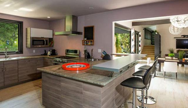La cocina es de estilo moderno y destaca por los acabados de granito y muebles empotrados. Este espacio conecta directamente con el comedor. (Foto: themls.com)