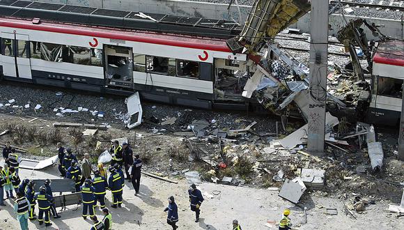 Cuerpos de las víctimas son evacuados después de una serie de explosiones que arrasaron cuatro trenes de cercanías en los alrededores de la estación de tren de Atocha en Madrid el 11 de marzo de 2004. (Foto de Christophe SIMON / AFP)