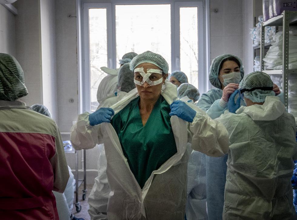Los trabajadores médicos se preparan para un turno que trata a pacientes con coronavirus en el hospital clínico Spasokukotsky en Moscú. (Yuri KADOBNOV / AFP)