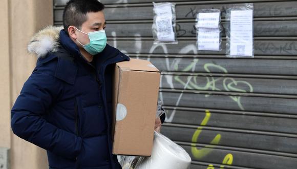 Italia, el país más afectado por el coronavirus en Europa y el segundo en el mundo, ha tomado medidas drásticas con el cierre total del comercio, salvo bienes de primera necesidad. En la imagen, un hombre camina con sus compras en Milán. (Foto: AFP)