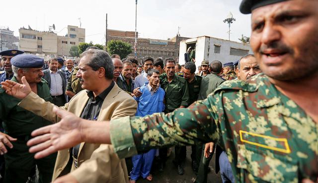 Hussein al-Sakit (in blue prison suit), 22, who was convicted of raping and murdering the five-year-old girl, Safaa al-Matari, is surrounded by policemen before his execution at the Tahrir Square in downtown Sanaa, Yemen August 14, 2017. REUTERS/Khaled Abdullah