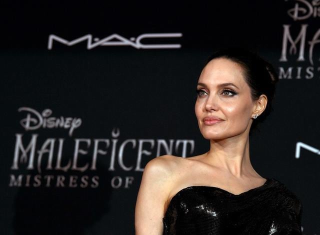 Angelina Jolie se presentó al estreno de la segunda parte de la película Maléfica. Lucio un vestido de la marca Versace. (Foto: AFP)