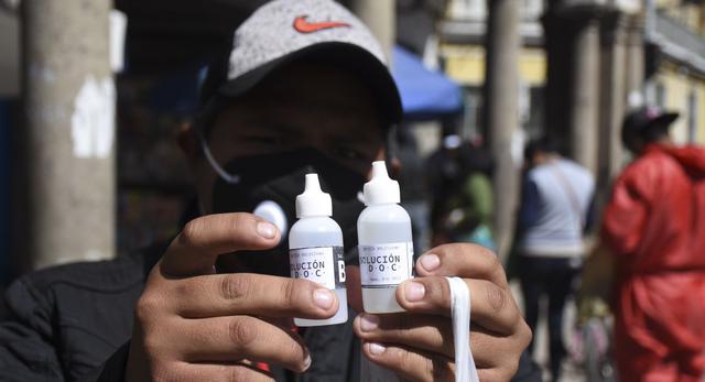 Un hombre muestra botellas de dióxido de cloro que compró en una farmacia en Cochabamba, en medio de la pandemia del coronavirus. (Foto: AP / Dico Solis).