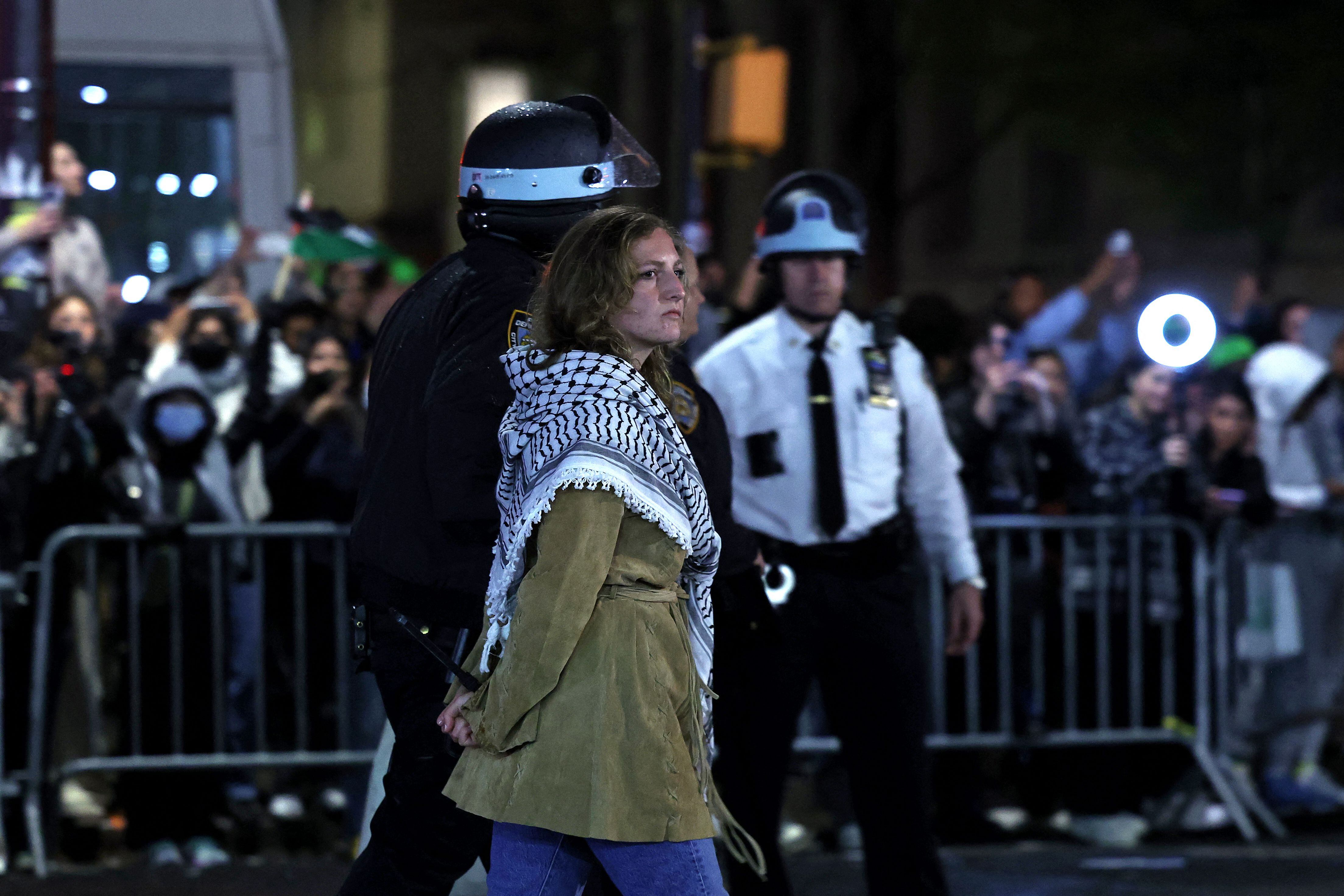 La policía de Nueva York arresta a una estudiante mientras desaloja un edificio que había sido tomado en la Universidad de Columbia. (Foto de CHARLY TRIBALLEAU / AFP).
