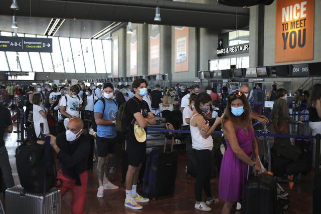 Personas hacen cola para registrarse para un vuelo de British Airways al aeropuerto de Heathrow, el viernes 14 de agosto de 2020. Imagen del aeródromo de Niza, en el sur de Francia. Ciudadanos están en alerta por segunda ola de coronavirus.  (AP/Daniel Cole).
