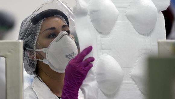 Una empleada trabaja en la producción de mascarillas N95 en una fábrica que produce 40.000 mascarillas por día en la Ciudad de México, el 21 de mayo de 2020. (Foto referencial, ALFREDO ESTRELLA / AFP).