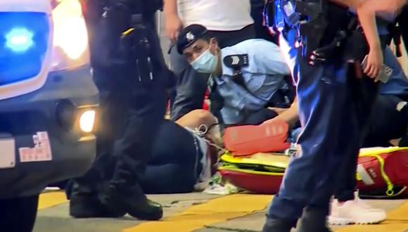 Un oficial de policía en el suelo recibe tratamiento médico luego de ser apuñalado por un hombre en una calle de Causeway Bay de Hong Kong, el jueves 1 de julio de 2021. (TVB/AP).