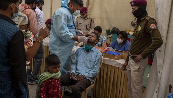 Un enfermero toma una muestra nasal de un pasajero en una prueba de COVID-19 en una terminal de ómnibus en Nueva Delhi, India, miércoles 24 de marzo de 2021. (AP Foto/Altaf Qadri).
