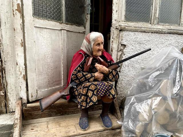 Una anciana con su escopeta en la puerta de su casa en Stepanakert, la capital del enclave separatista de Nagorno Karabaj disputada por Azerbaiyán y Armenia, que ha vuelto a ser atacada con cohetes. (EFE/Pablo González).