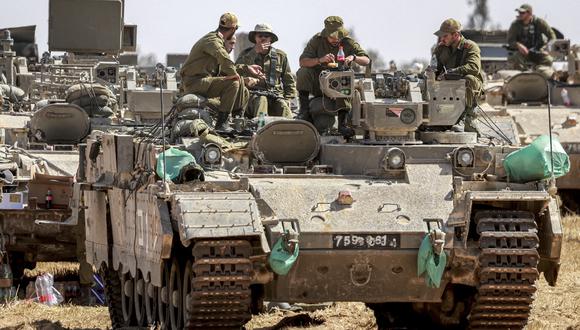 Soldados del ejército de Israel sentados encima de un vehículo de combate de infantería (IFV) estacionado en una posición cerca de la frontera con la franja de Gaza. (Foto de Menahem KAHANA / AFP).