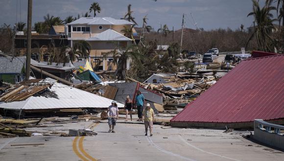 La gente camina frente a casas y negocios destruidos tras el paso del huracán Ian en Matlacha, Florida.