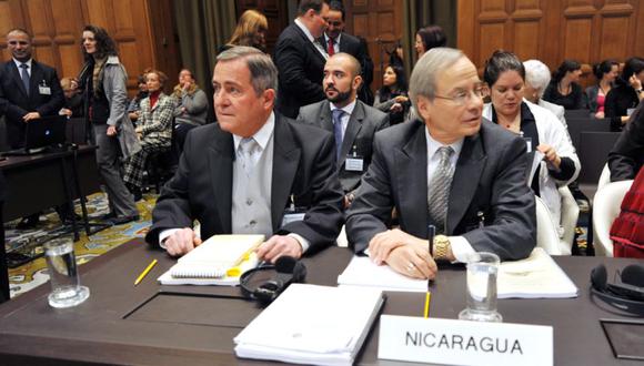 El agente de Nicaragua ante la corte, Carlos Jorge Argüellos Gómez (izquierda), se sienta junto al abogado Paul S. Reichler antes de una audiencia en la Corte Internacional de Justicia en La Haya el 14 de octubre de 2013. (Foto: MAUDE BRULARD / AFP)