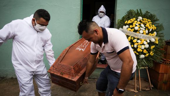 Trabajadores de una funeraria vestidos con ropa protectora y un pariente llevan el ataúd de José Barreto, quien murió de coronavirus en su casa en el barrio Jorge Teixeira en Manaos, Brasil. (Foto: REUTERS / Bruno Kelly).