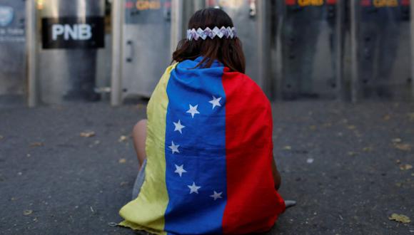 Imagen referencial. Una niña lleva una bandera venezolana en una calle de la capital Caracas, Venezuela, el 20 de enero de 2018. (REUTERS/Marco Bello).