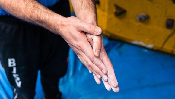 Un hombre frotándose las manos con un poco de polvo de talco antes de entrenar. | Imagen referencial: Enric Cruz / Pexels