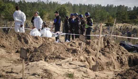 Técnicos forenses trabajan en un lugar de enterramiento cerca de la ciudad recientemente recuperada de Lyman, área de Donetsk, Ucrania, el 7 de octubre de 2022. (Foto: EFE/EPA/YEVGEN HONCHARENKO)