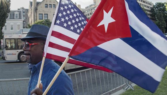 Durante su campaña, Biden prometió a Cuba revertir las restricciones de Trump a los viajes y al envío de dinero que los cubanos en el exterior mandan a sus familiares en la isla. En la foto, un hombre ondea las banderas de Estados Unidos y Cuba en Washington, DC. (PAUL J. RICHARDS / AFP)