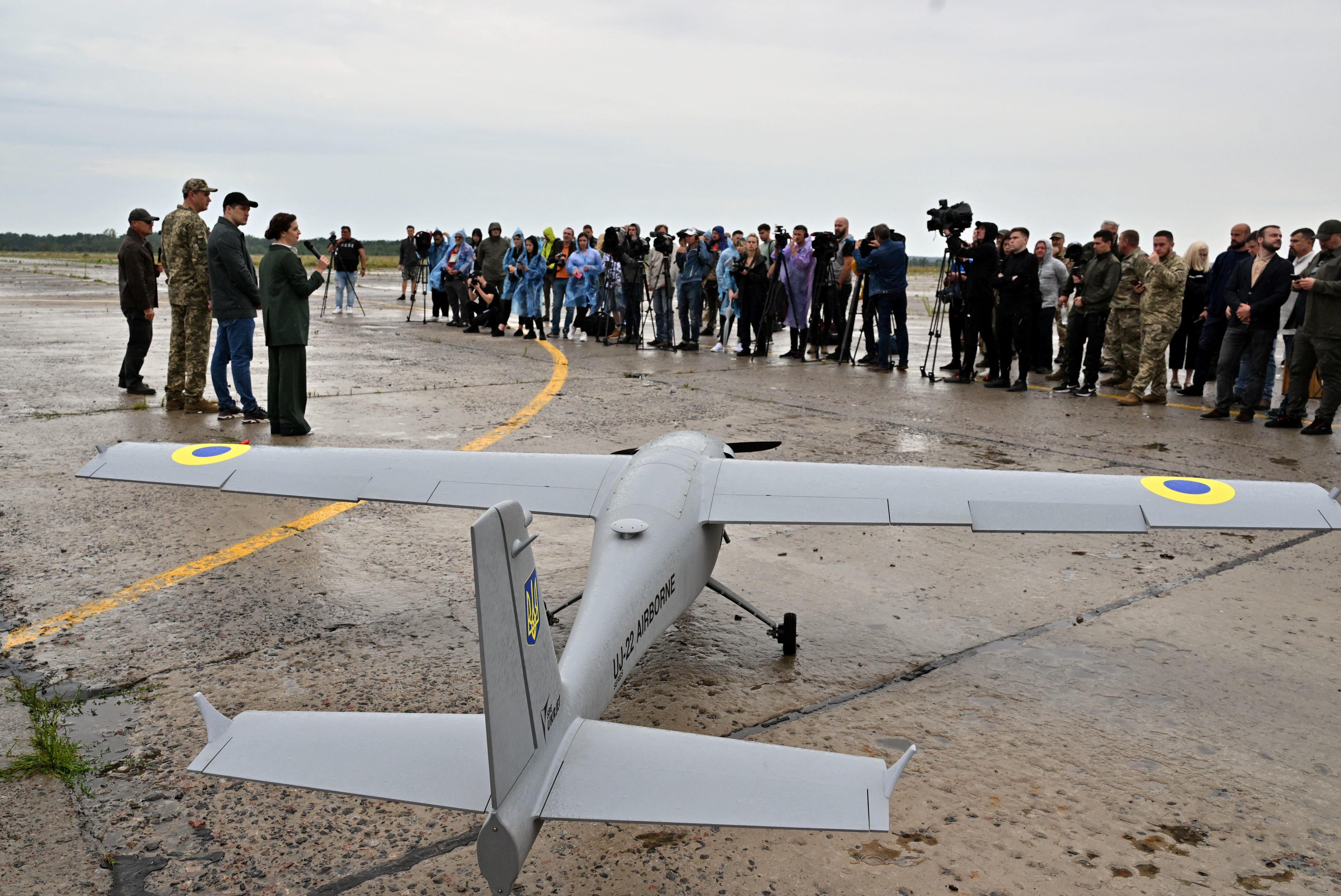 Journalists attend the unveiling of a UJ-22 Airborne reconnaissance drone in Kiev, Ukraine, on August 2, 2022, before it is sent to the front lines of the war.  (Photo by Sergei SUPINSKY / AFP).