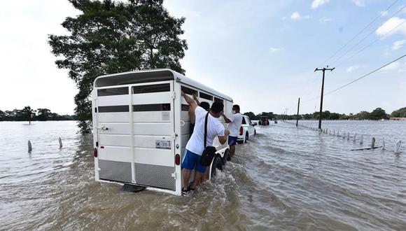 La gente se traslada en camionetas entre las calles inundadas debido a las constantes lluvias que ha originado la tormenta tropical Gamma, este lunes, en el poblado de Gaviotas Sur, en el estado de Tabasco (México). (EFE/Jaime Avalos).