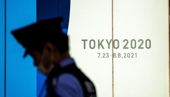 Japón: un policía pasa junto a la señalización de los Juegos Olímpicos de Tokio 2020 el 15 de julio de 2021. (Foto de Behrouz MEHRI / AFP).