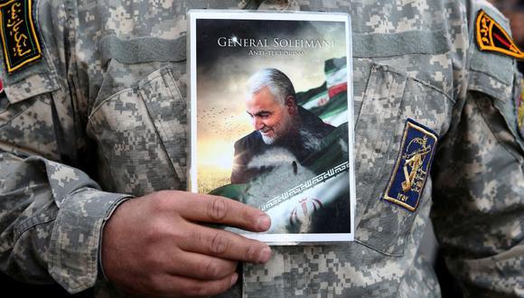 Un militar iraní sostiene la foto de Qassem Soleimani durante una protesta contra el asesinato del jefe de la élite de la Fuerza Quds, y el comandante de la milicia iraquí Abu Mahdi al-Muhandis que murieron en un ataque aéreo en el aeropuerto de Bagdad (Foto: Reuters).