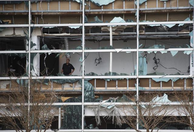 Un hombre observa los daños dentro de la torre Capitol One Bank Tower, con las ventanas reventadas en el centro de  Lake Charles, Louisiana, tras el impacto del huracán Laura. (Foto de ANDREW CABALLERO-REYNOLDS / AFP).