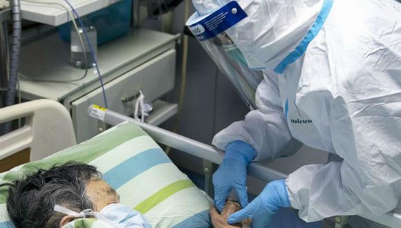 La imagen muestra a una enfermera sosteniendo la mano del paciente para consolarlo mientras está en la UCI. (Foto: Referencial/AFP)