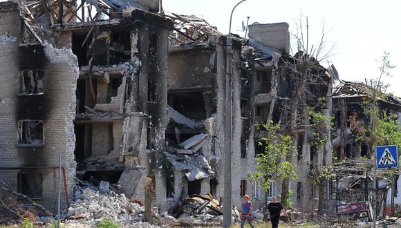 Los residentes locales pasan frente a los edificios de apartamentos destruidos durante el conflicto entre Ucrania y Rusia en la ciudad de Sievierodonetsk en la región de Lugansk, Ucrania.