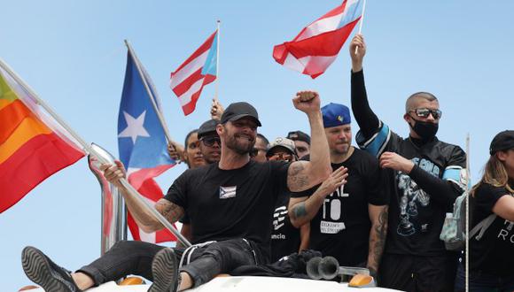 El cantante Ricky Martin, junto al rapero René Pérez, también conocido como Residente, marchan a lo largo de la carretera Las Américas en una huelga nacional que pedía la renuncia de Ricardo Rosselló. (Foto: AFP)
