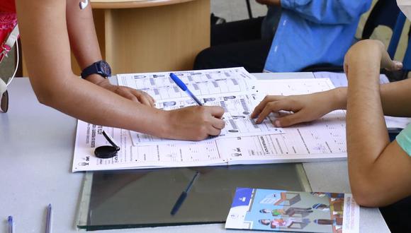 Una ciudadana firmando en su casilla de la lista de electores tras emitir su voto. (Foto: GEC)