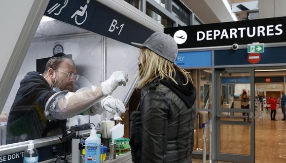Imagen referencial. Un médico recolecta una muestra de hisopo de un viajero en un centro de pruebas rápidas de coronavirus COVID-19 en el aeropuerto Ben-Gurion de Israel en Lod, cerca de Tel Aviv, el 19 de enero de 2021. (JACK GUEZ / AFP).