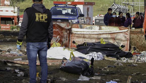 Un miembro del Ministerio Público se encuentra cerca de los cadáveres después de una estampida después de un concierto por el día de la independencia de Guatemala en Quetzaltenango, el 15 de septiembre de 2022. (Foto: Henry GONZALEZ / AFP)