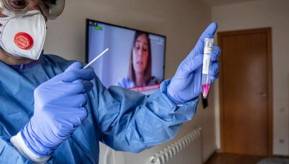 Un experto analiza una muestra de un paciente con síntomas de coronavirus en un hospital de Vilamajor, en España. (AFP)
