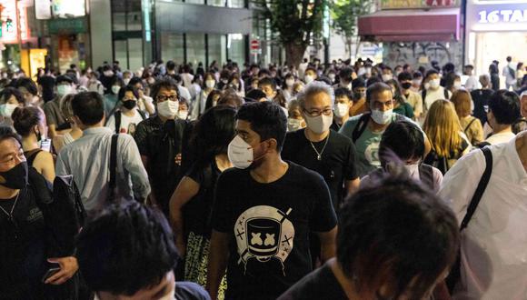 Personas con mascarillas caminan en el distrito Shinjuku de Tokio el 17 de julio de 2021, después de que la ciudad registrara su mayor número de casos de coronavirus Covid-19 desde enero. (Foto de Yuki IWAMURA / AFP).