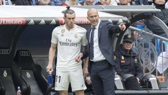 Zinedine Zidane charlando con Gareth Bale en la zona técnica del Bernabéu. (Foto: EFE)