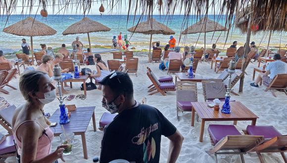 Turistas disfrutan de un restaurante de playa en Playa del Carmen, estado de Quintana Roo, México, el 3 de marzo de 2021, en medio de la pandemia de coronavirus. (Foto de Daniel SLIM / AFP).