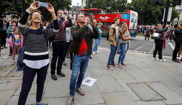 People use their phones to film as the 'Big Ben' bell chimes for the last time in four years ahead of restoration work on the Elizabeth Tower, which houses the Great Clock and the 'Big Ben' bell, at the Houses of Parliament in London, Britain August 21, 2017. REUTERS/Peter Nicholls