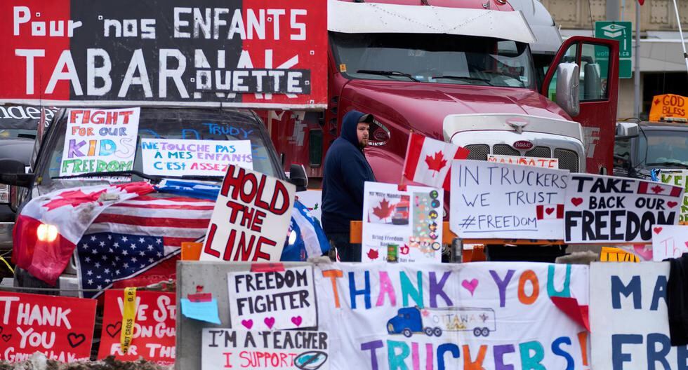 Una persona se para en medio de carteles de apoyo a los camioneros que protestan por los mandatos de vacunación en el centro de Ottawa, Ontario, Canadá, el 9 de febrero de 2022. (EFE/EPA/ANDRE PICHETTE).