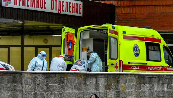 Personal médico saca de una ambulancia a una persona en la sección de pacientes infectados de coronavirus en el hospital Pokrovskaya en San Petersburgo, Rusia, el 24 de enero de 2022. (Olga MALTSEVA / AFP).
