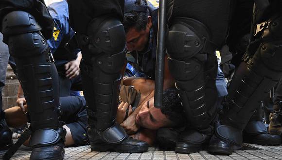 Un hombre es reducido por la policía durante una manifestación contra la "ley ómnibus" frente al Congreso, mientras los congresistas llevan a cabo el debate del proyecto de ley, en Buenos Aires el 31 de enero de 2024. (Foto de Luis ROBAYO / AFP)
